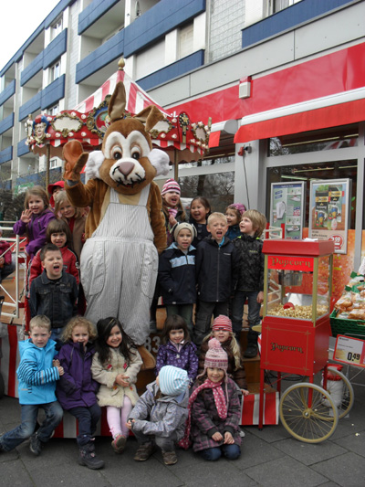 An einem sonnigen Tag vor Ostern wurde im "Nahkauf" an der Luxemburger Strasse in Herm&uuml;lheim das Osterfest schon einmal mit Kindern des St.Severin Kindergartens gefeiert. Der Osterhase war nat&uuml;rlich extra von den Osterinseln angereist und hatte viel Spa&szlig; mit den Kindern und ihrer Leiterin, Frau Keller. Auch der Ortsvorsteher David Boventer und die Herrn Steko und Irrgang von der REWE Gruppe waren dann dabei, als von Kindern der "Wackelzahngruppe" im Garten hinter dem"Nahkauf" die flei&szlig;ige Ostereiersuche &auml;u&szlig;erst erfolgreich verlief. (Photo: David Boventer - Nutzung mit freundlicher Genehmigung der Eltern und der Kindergartenleitung)
