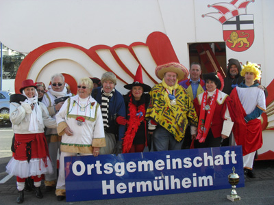 Der Zug in Herm&uuml;lheim war spitze! Er w&auml;chst und gedeiht, unser Zog in Herm&ouml;llem. Sch&ouml;n, dass alle mitmachen. Danke auch an die "Macher" Sascha, Oliver, Ruth und Ina und an die Sch&uuml;ler und Eltern der Deutschherrenschule, die allein mit 130 Teilnehmern dabei waren. Das sch&ouml;nste Kost&uuml;m konnte die Caritas mit der Anna-Haus-Fu&szlig;truppe vorweisen. Gratulation!!! Auf dem Bild sehen wir die Karnevalisten, die auf dem Wagen der Ortsgemeinschaft mitgefahren sind. Es hat viel Spa&szlig; gemacht!